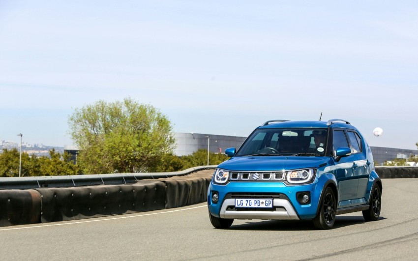 a blue jeep driving down a road next to a bridge