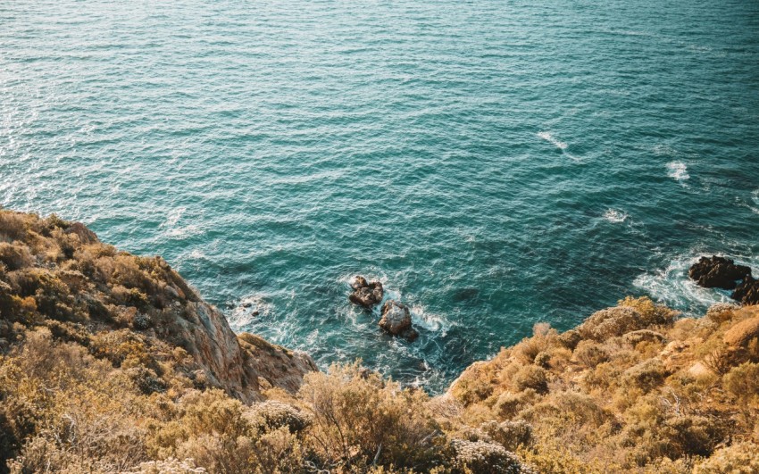 brown rock formation beside body of water during daytime