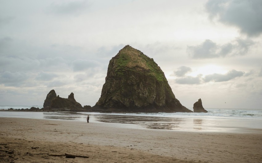 person on shore near rock mountain at adytime