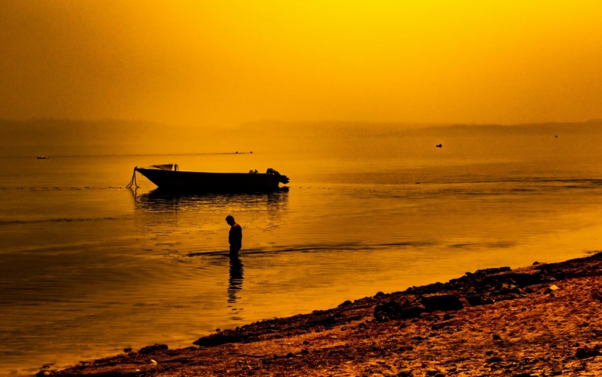 a person standing in the water near a boat