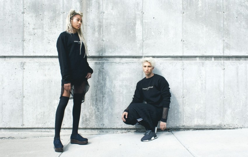 man kneeling and woman standing near wall