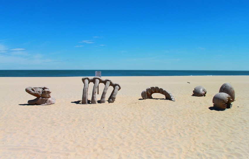 a group of rocks sitting on top of a sandy beach