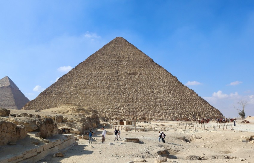 a group of people standing in front of a pyramid