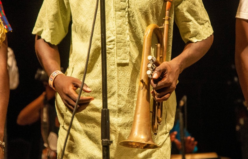 man in beige button up shirt holding brass trumpet