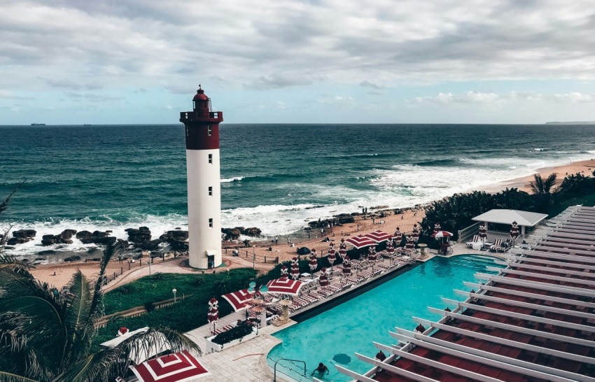 white and red lighthouse near body of water during daytime