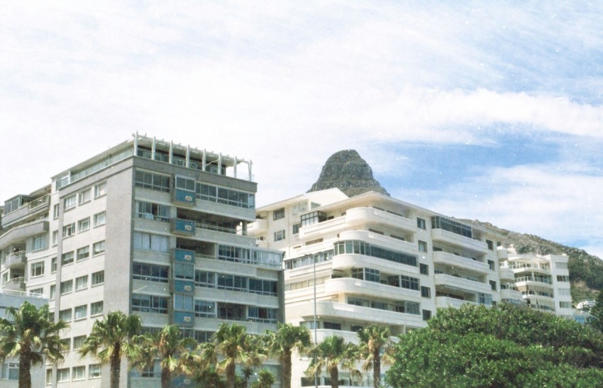 a large white building with a mountain in the background