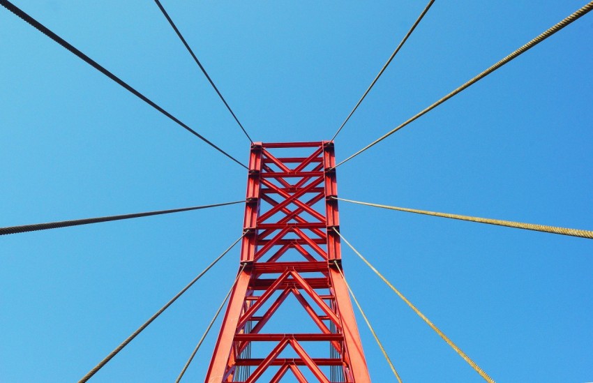 red metal bridge under blue sky during daytime