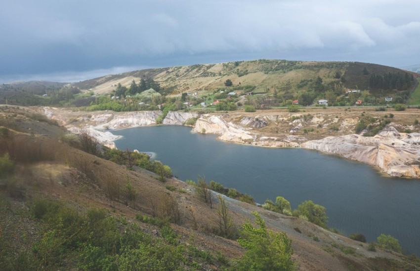 a large body of water sitting on top of a lush green hillside