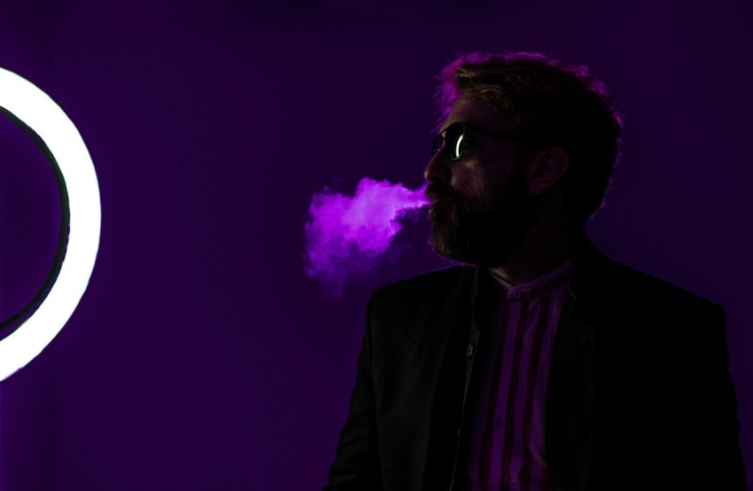 a man standing in front of a purple light