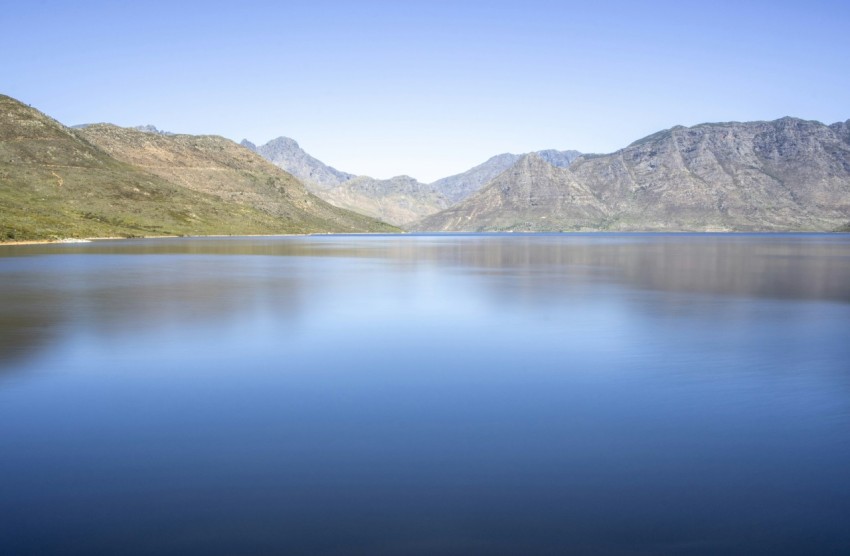 lake near mountain under blue sky during daytime