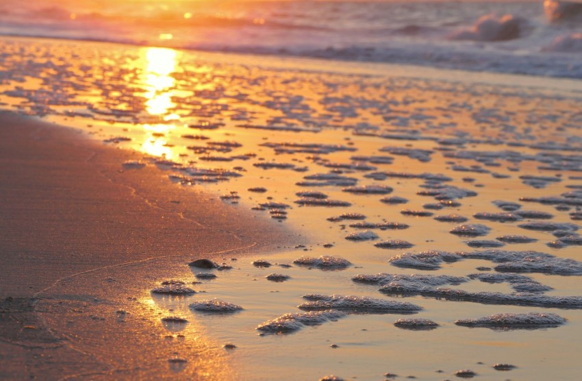 the sun is setting over the water at the beach fguQo3