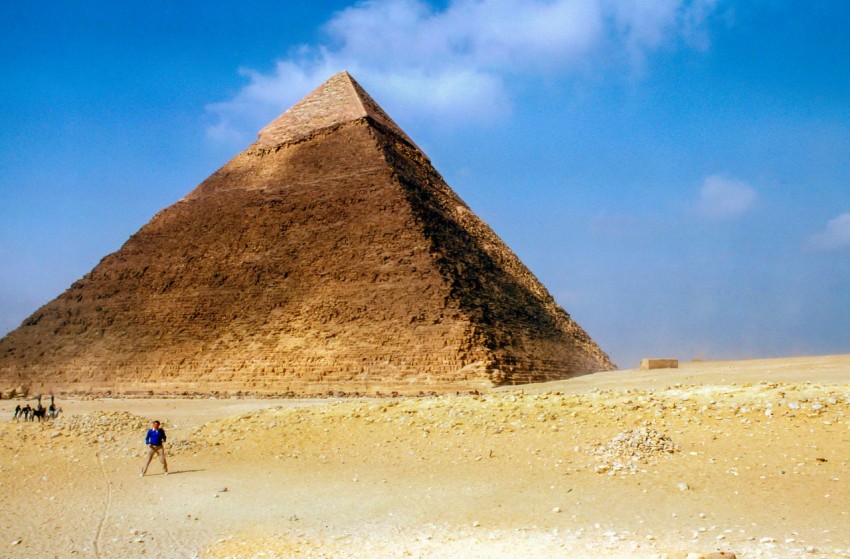 man standing near pyramid giza during daytime