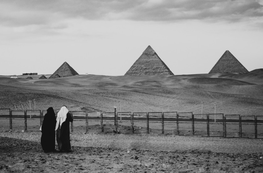 a person standing in front of three pyramids