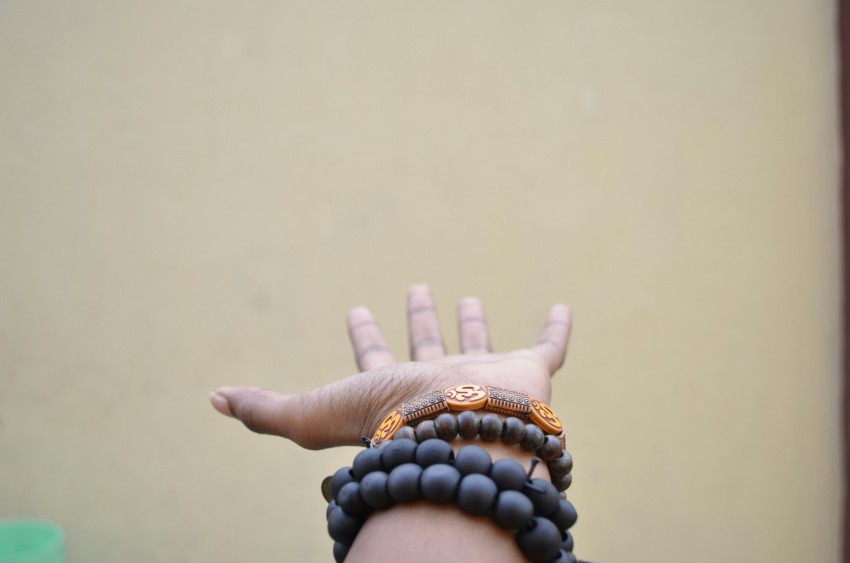 person hand with black beaded bracelets SAFYn1O