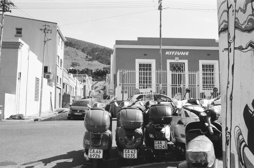 a black and white photo of motorcycles parked in front of a building