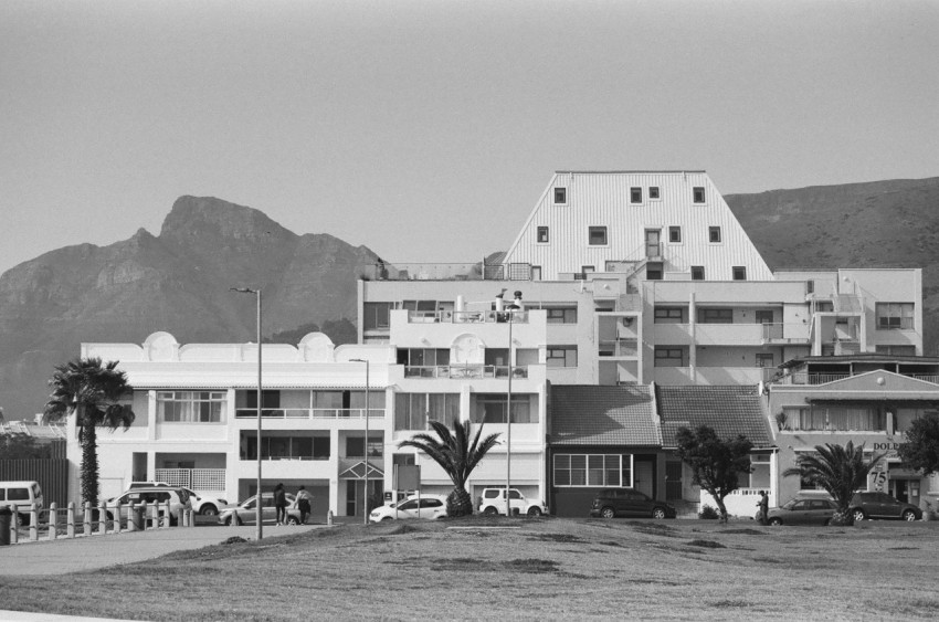 a black and white photo of a building with mountains in the background RhBYlatA