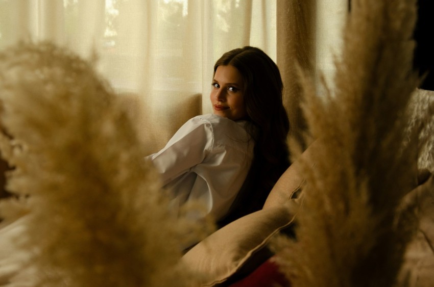 a woman sitting on a couch in front of a window