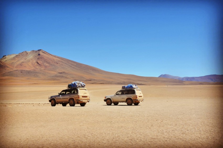 two grey suvs on grey desert