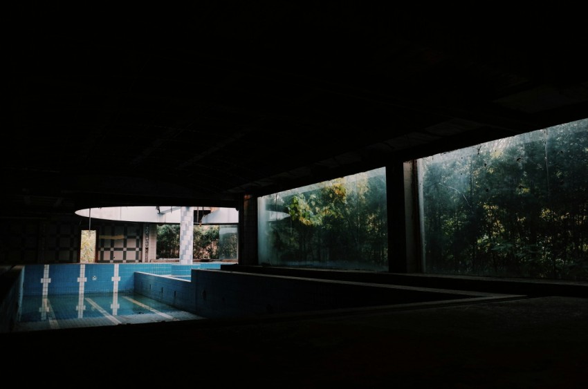 a dark room with a pool in the middle of it