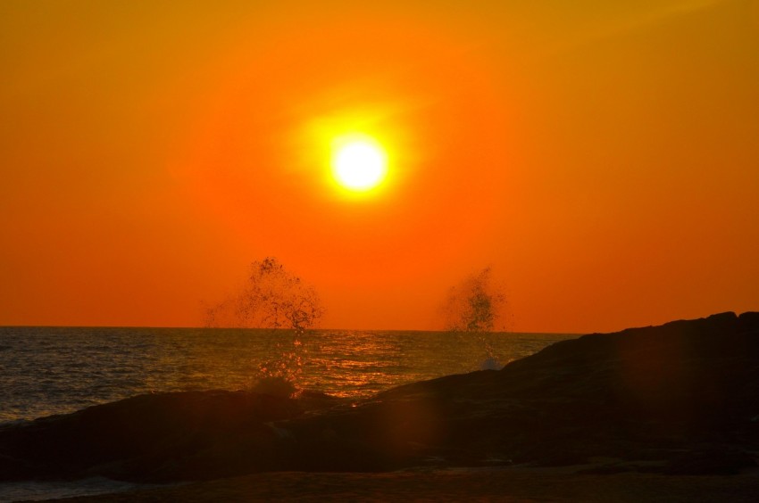 the sun is setting over the ocean with waves