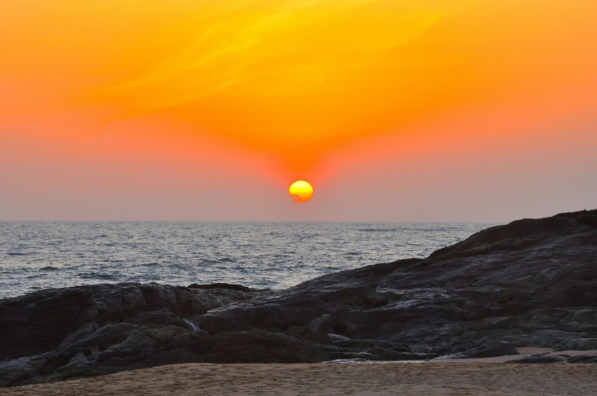 the sun is setting over the ocean on the beach 53788kD