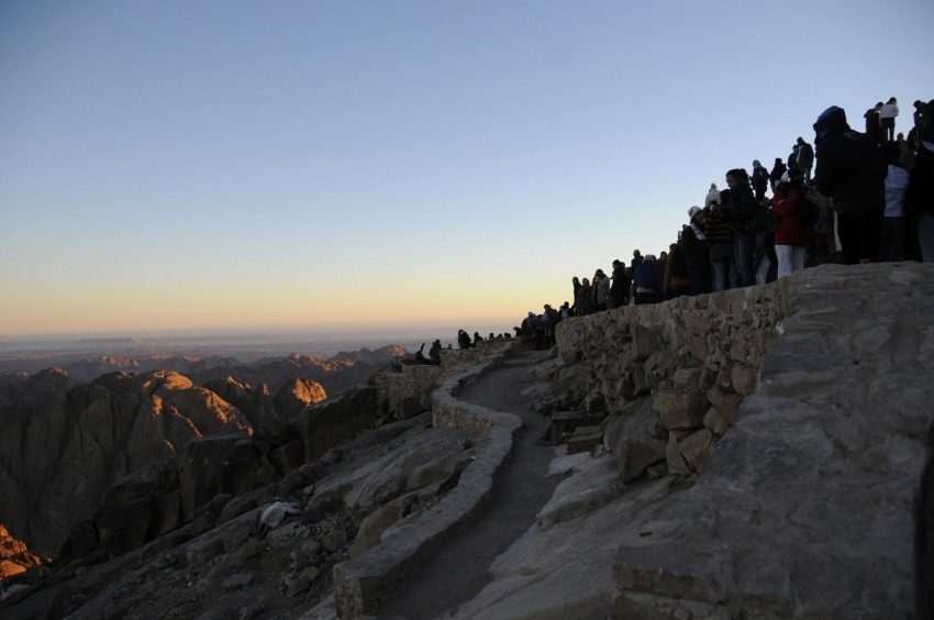 a group of people standing on top of a mountain grcaG