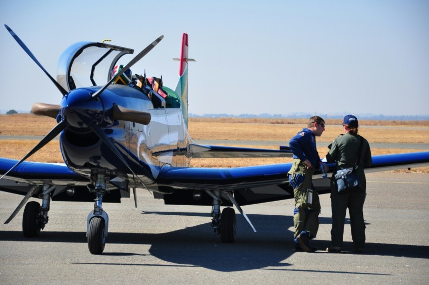 two persons standing near blue jet plane during daytime tzmTCnh9G