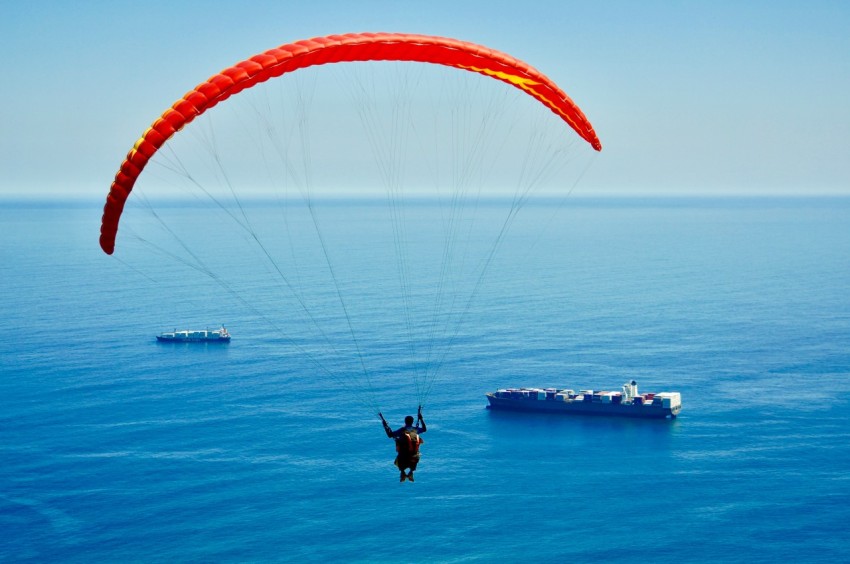 man on parachute above sea