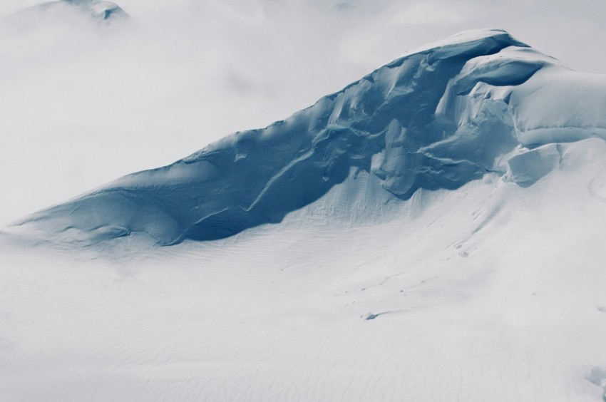 a snowy mountain with a valley below