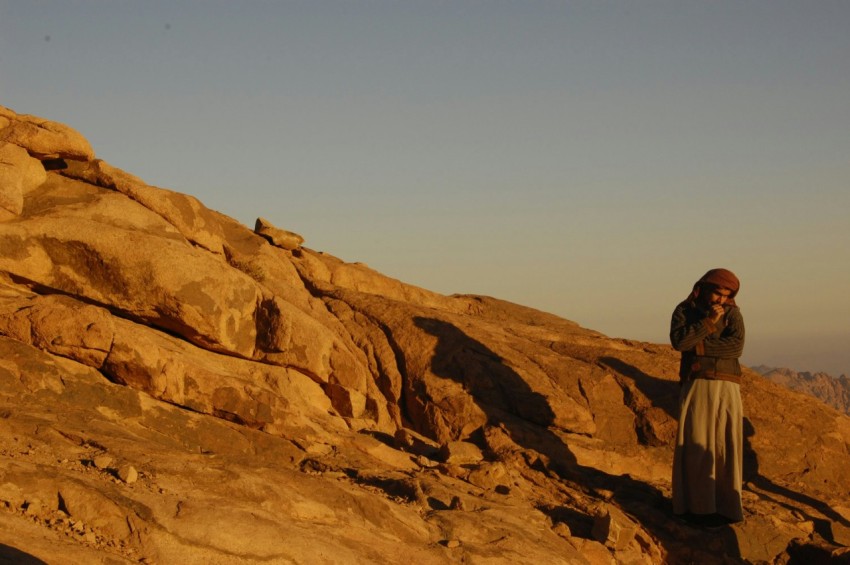 a woman standing on top of a rocky hillside