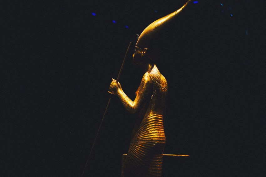 a statue of an egyptian woman holding a staff J