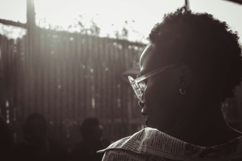 a woman with glasses looking off into the distance