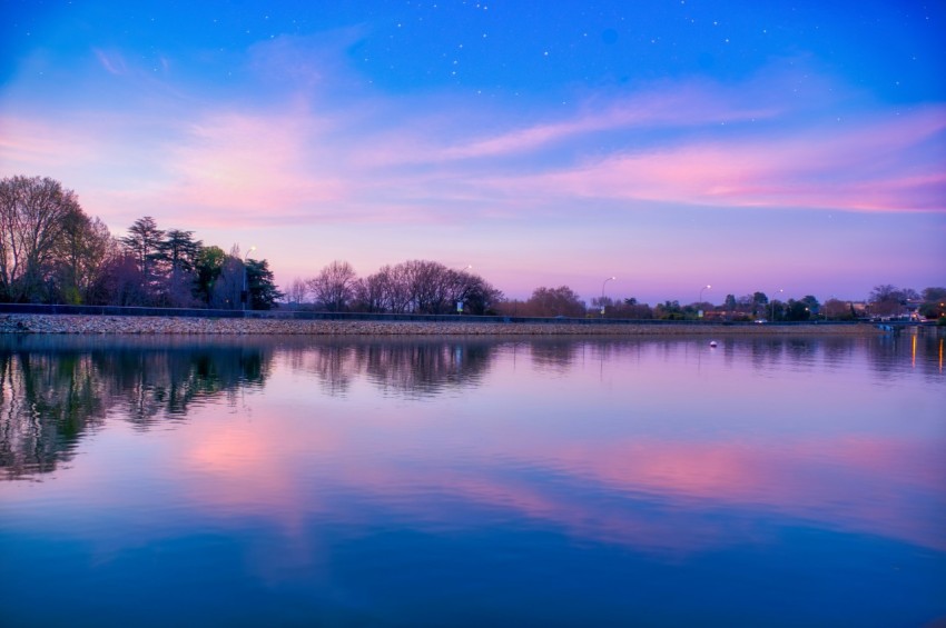 body of water near trees under blue sky during daytime