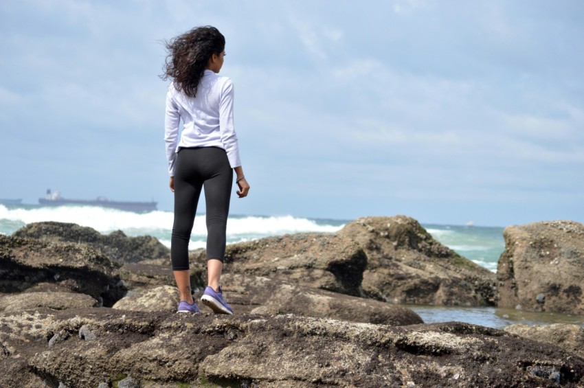 woman standing on rock boulder