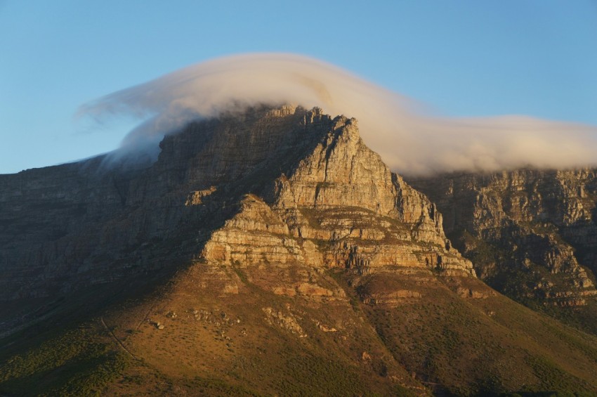 clouds touching brown mountain