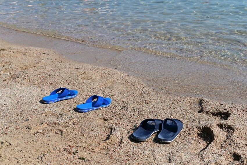 blue and black flip flops on beach yYe