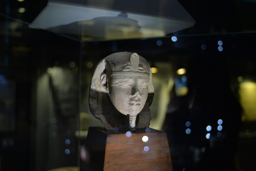 gray human face bust on brown wooden table