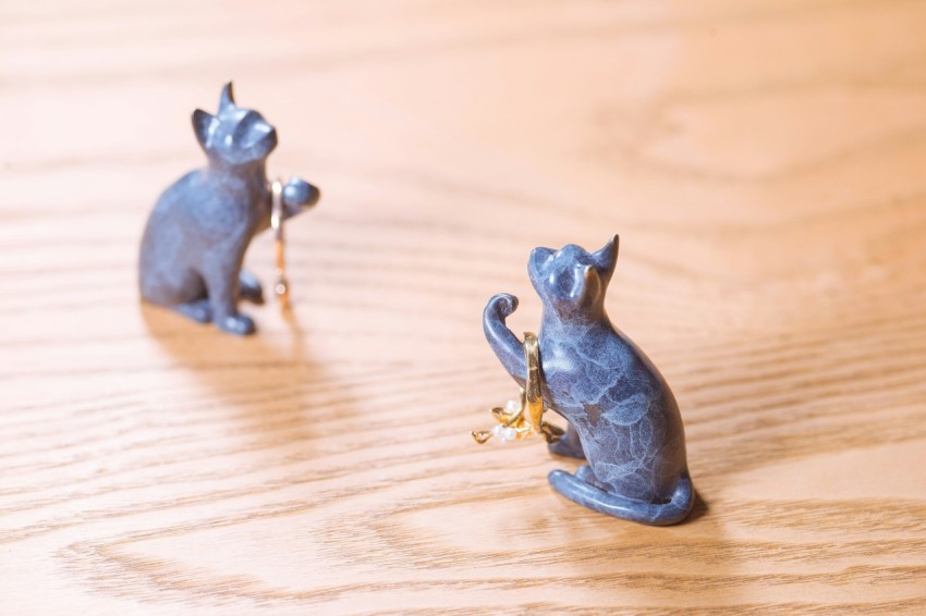 a couple of small figurines of cats on a table