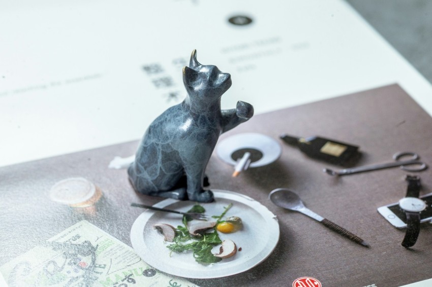 a cat figurine sitting on top of a plate