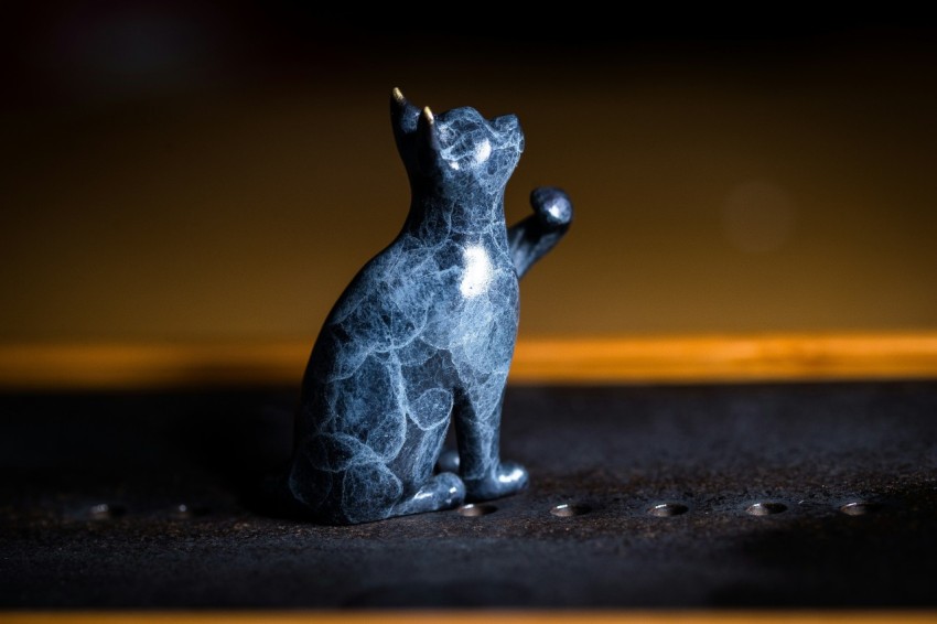 a cat figurine sitting on top of a table