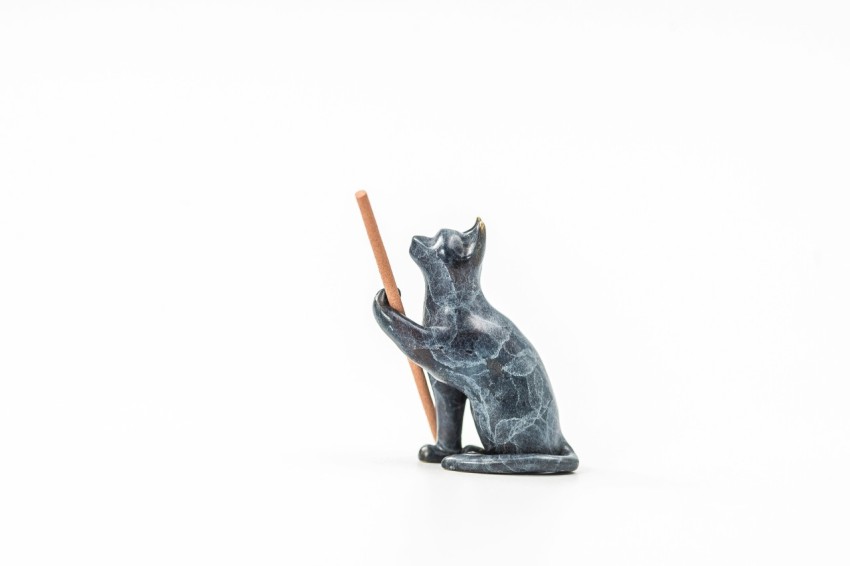 a statue of a cat holding a stick