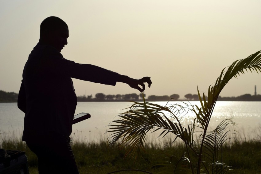 a man standing in front of a body of water