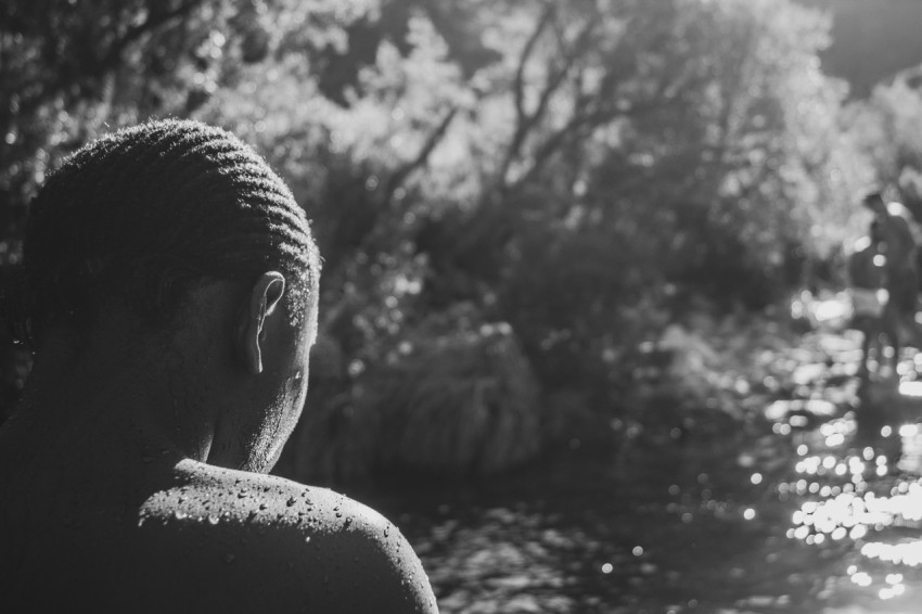 a woman standing in front of a body of water