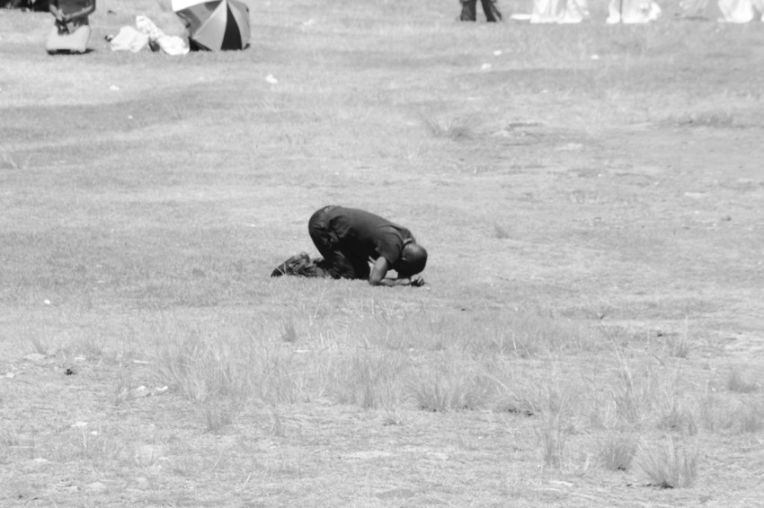 person praying on grass field