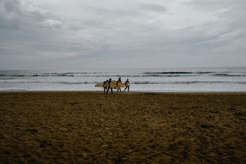 a couple of people riding horses on top of a beach