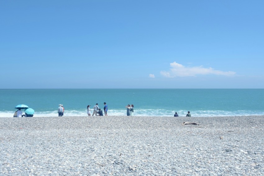 a group of people standing on top of a sandy beach