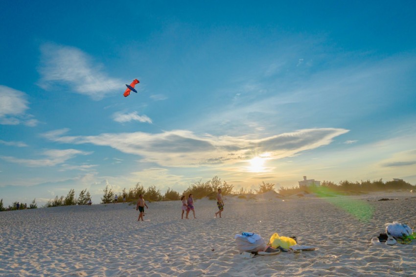 a group of people standing on top of a sandy beach