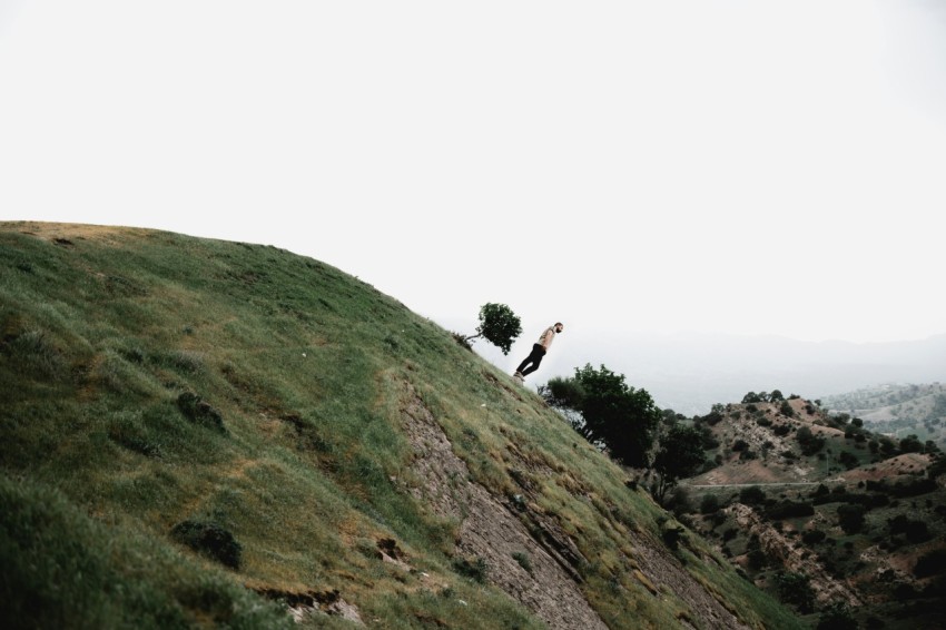 a couple of people standing on top of a lush green hillside