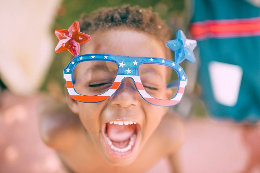 boy wearing american flag print eyeglasses sticking his mouth open lQL