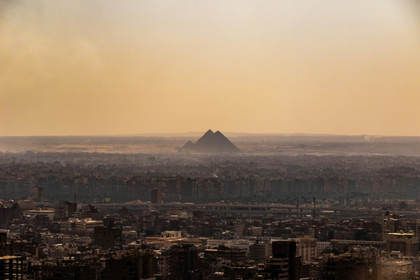 a view of a city with a pyramid in the distance